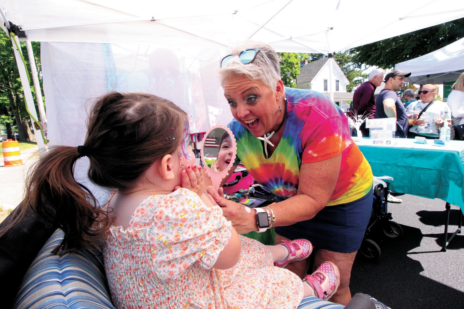 ALWAYS POPULAR: At right Toni Andersen of Warwick  barely paused from the moment the Gaspee Days Arts and Crafts officially opened Saturday morning. Her face paintings delighted kids of all ages including Violet who is pictured here. As typically the case, parents ask how they wash faces clean and kids protest when they learn they won’t last.